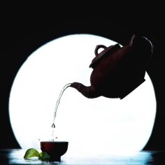 Flying tea pot silhouette against a full Moon silhouette. Asian tea ceremony pouring tea with copy