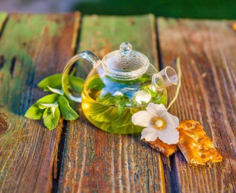 Tea pot of herbal tea on a wooden table